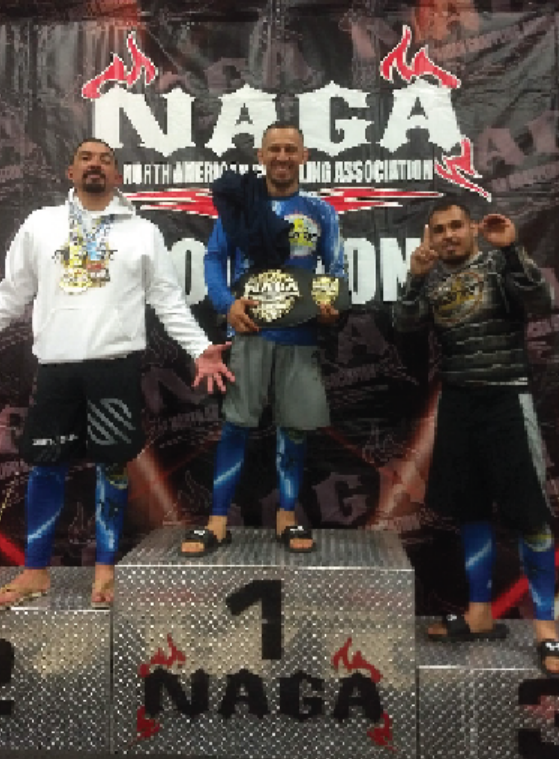 Three male jiu-jitsu champions wearing 10th Planet Beaumont gear and medals standing on a winner's podium.